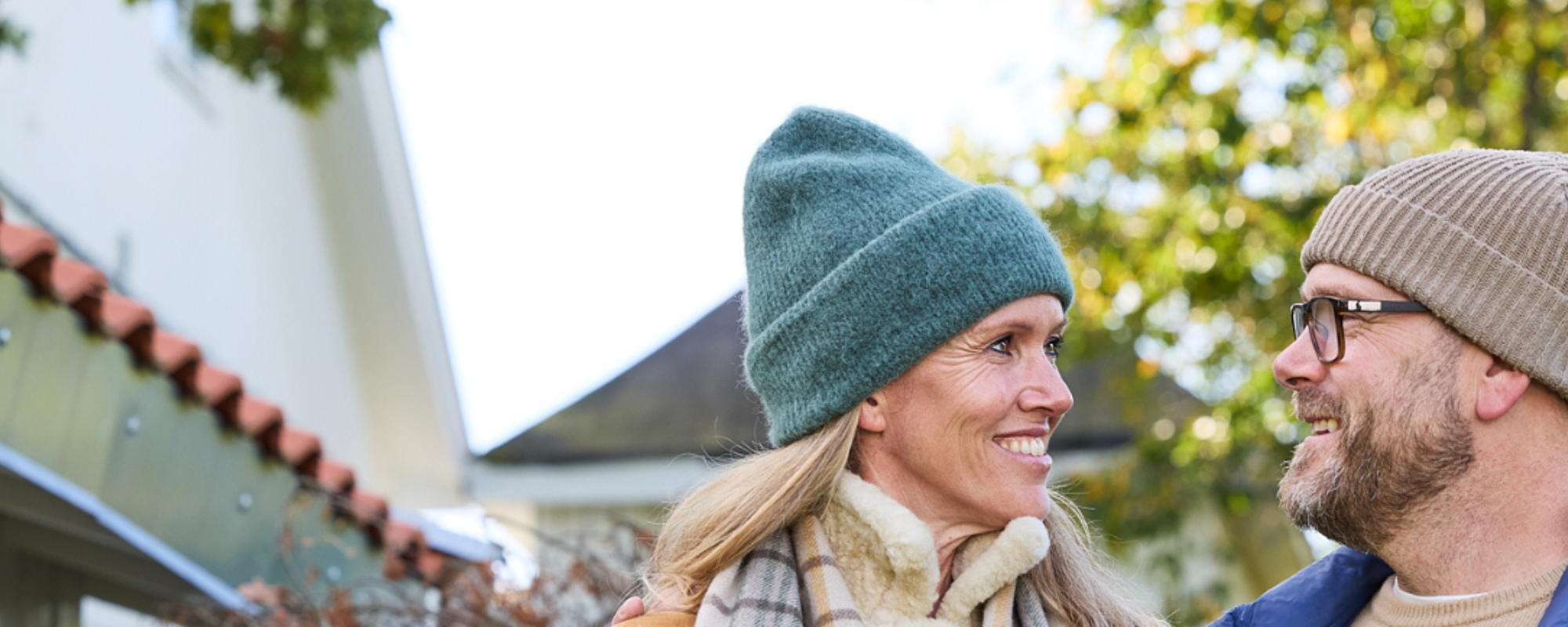 Ett par som står utomhus och tittar med ett leende på varandra