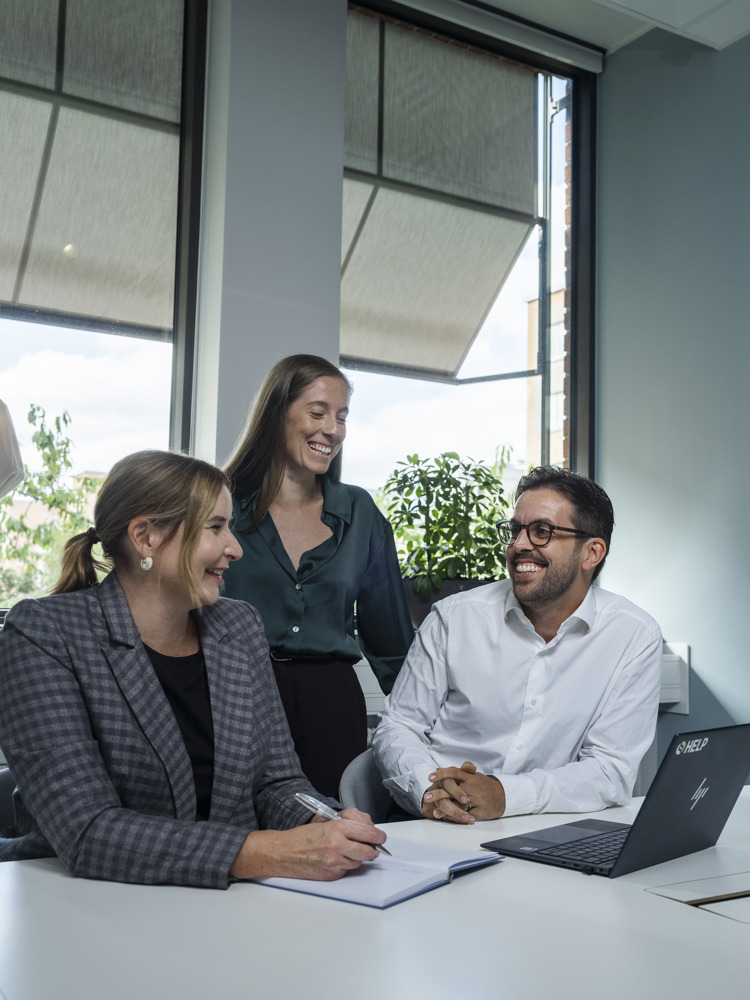 två kvinnor och en man som skrattar tillsammans