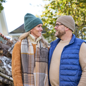 Ett par som står utomhus och tittar med ett leende på varandra