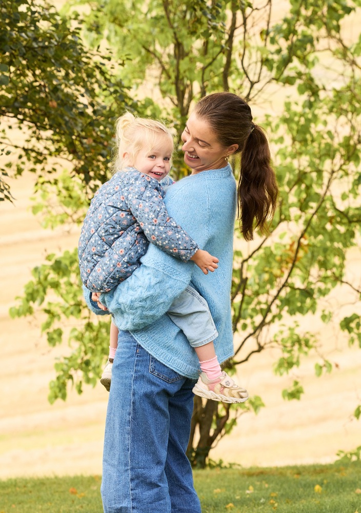 Kvinna som håller i ett barn och ler