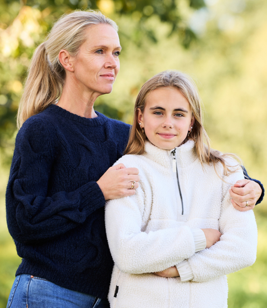 Kvinna som står och håller om sitt barn