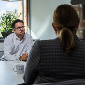 en man som sitter i möte med två kollegor